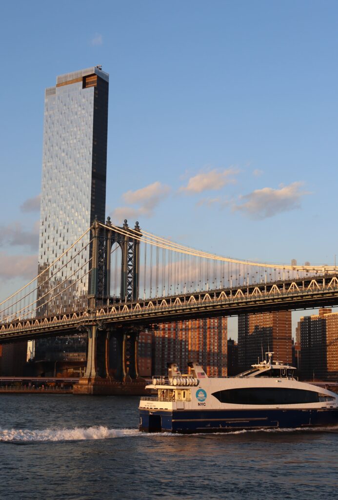 The New York City ferry going under the Manhattan Bridge in Dumbo Brooklyn
