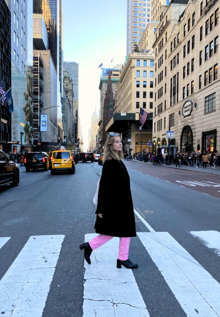 A girl crossing the 5th Avenue Street in New York City.